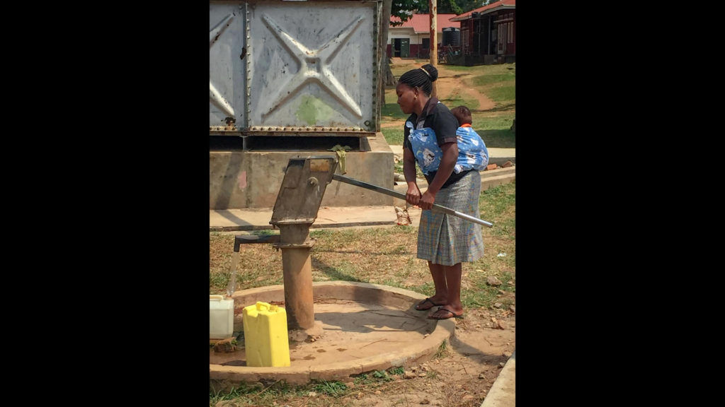 At the hospital, family members pump water to wash bedclothes for the patients